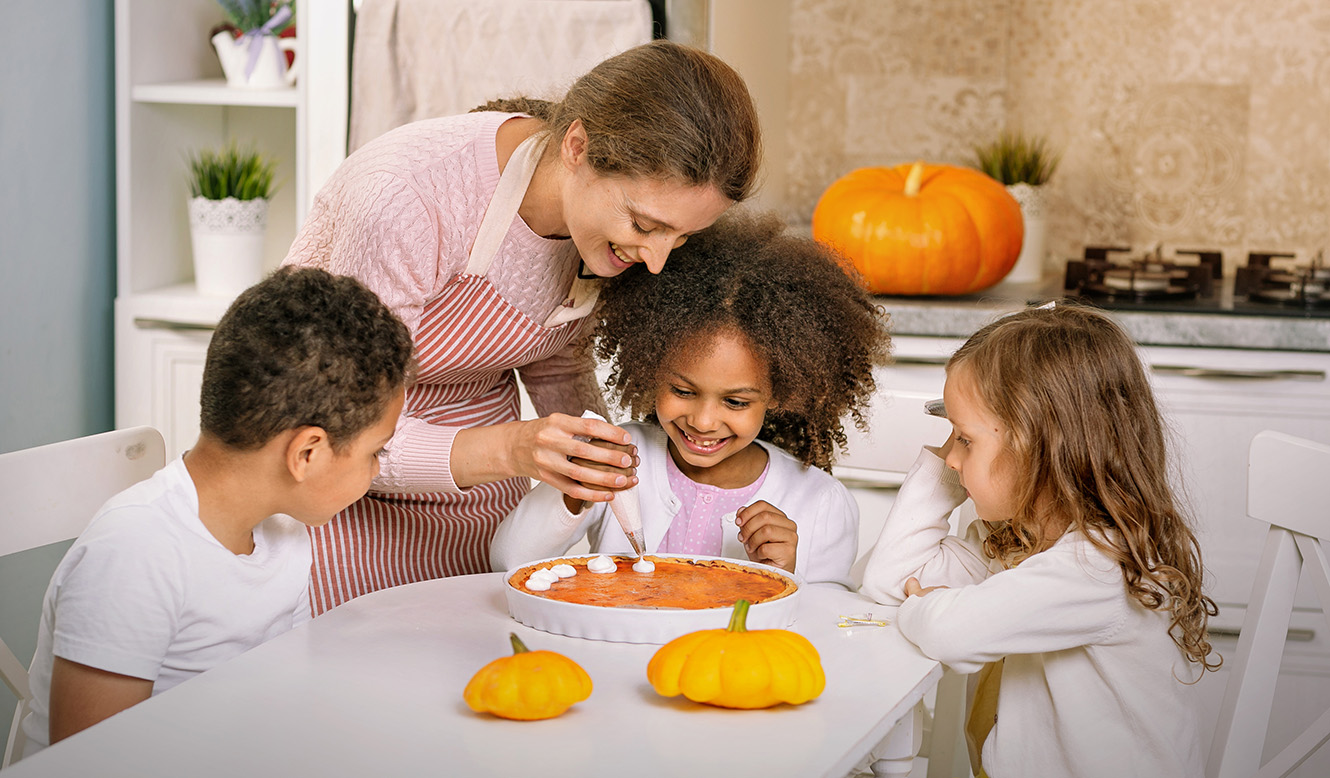 family decorating pumpkin pie