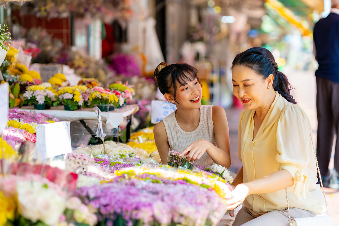 mother and daughter looking at flowers at market