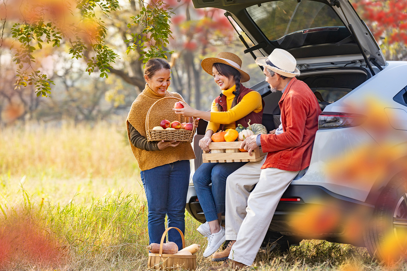 family sitting outside car
